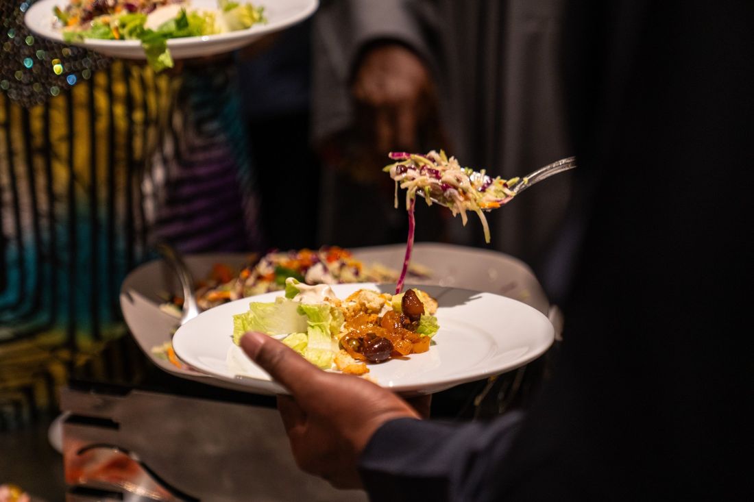 Guest being served salad at an event buffet